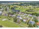 Panoramic aerial view of homes in a golf course community, showcasing lush greenery, a waterway, and swimming pools at 6780 Greenbrier Dr, Seminole, FL 33777