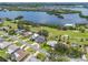 An aerial view of waterfront homes in a golf community, featuring mature trees, lush fairways, and serene lake views at 6780 Greenbrier Dr, Seminole, FL 33777
