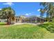 Backyard view of the enclosed pool, lawn, and home at 6780 Greenbrier Dr, Seminole, FL 33777
