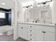 Bright bathroom featuring double sink vanity with white cabinets and a tub-shower combo with dark tile at 6780 Greenbrier Dr, Seminole, FL 33777