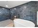 Bathroom showcasing a standalone tub and elegant dark tiling in the shower area at 6780 Greenbrier Dr, Seminole, FL 33777