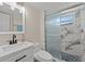 Bathroom with a sliding glass door shower, marble-look tiles, and modern fixtures for a contemporary feel at 6780 Greenbrier Dr, Seminole, FL 33777