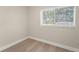 Bright bedroom showcasing a window with blinds and light wood-style flooring at 6780 Greenbrier Dr, Seminole, FL 33777