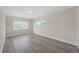 Bright bedroom with two windows and light wood-style flooring, offering ample natural light at 6780 Greenbrier Dr, Seminole, FL 33777
