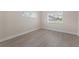 Neutral bedroom featuring updated flooring and natural light from two windows at 6780 Greenbrier Dr, Seminole, FL 33777