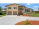 Inviting tan two-story home featuring a two-car garage, balcony, and well-manicured landscaping at 6780 Greenbrier Dr, Seminole, FL 33777