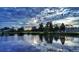 Beautiful lake reflecting trees and a vibrant cloudy sky at 6780 Greenbrier Dr, Seminole, FL 33777