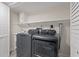 Efficient laundry room with modern washer and dryer, complemented by storage and shelving at 6780 Greenbrier Dr, Seminole, FL 33777