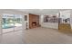 Bright living room featuring a brick fireplace, open access to the pool, and adjacent kitchen at 6780 Greenbrier Dr, Seminole, FL 33777