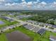 Panoramic aerial view of residential properties near a pond, showcasing the desirable neighborhood landscape at 8119 Trimbelle Ter, Parrish, FL 34219