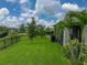 Expansive backyard with lush green lawn, a charming tree, and a screened-in porch for relaxed outdoor living at 8119 Trimbelle Ter, Parrish, FL 34219