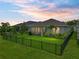 Fenced backyard featuring a well-maintained lawn, lush landscaping, and an enclosed lanai at 8119 Trimbelle Ter, Parrish, FL 34219