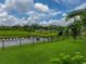 A serene backyard view with a pond, well-maintained lawn, and privacy fencing creates a peaceful retreat at 8119 Trimbelle Ter, Parrish, FL 34219