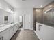 Bright bathroom features double vanity with quartz countertops and a tiled walk-in shower with glass enclosure at 8119 Trimbelle Ter, Parrish, FL 34219