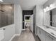 Bright bathroom features double vanity with quartz countertops and a tiled walk-in shower with glass enclosure at 8119 Trimbelle Ter, Parrish, FL 34219