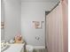 Clean bathroom featuring a shower with pink curtain and decorative towel racks at 8119 Trimbelle Ter, Parrish, FL 34219