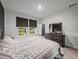 Sunlit bedroom with a dresser, cozy bed, and a view to the outside through two windows at 8119 Trimbelle Ter, Parrish, FL 34219