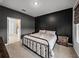 Bedroom with dark accent wall, metal bed frame, and view into the ensuite bathroom at 8119 Trimbelle Ter, Parrish, FL 34219