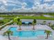 The aerial view shows a community pool area with lounge chairs, palm trees and cabanas, next to a lake at 8119 Trimbelle Ter, Parrish, FL 34219