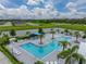 Aerial view of the community pool featuring sun loungers, shaded cabanas, and scenic water views at 8119 Trimbelle Ter, Parrish, FL 34219