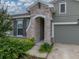 Close up shot of the exterior entrance with green bushes and stone archway at 8119 Trimbelle Ter, Parrish, FL 34219