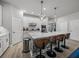 Kitchen island with seating, quartz countertops, stainless steel appliances, and pendant lighting at 8119 Trimbelle Ter, Parrish, FL 34219