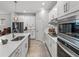 Modern kitchen featuring white cabinets, stainless steel appliances, quartz countertops, and wood flooring at 8119 Trimbelle Ter, Parrish, FL 34219