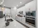 Bright kitchen featuring white cabinets, stainless steel appliances, quartz countertops, and modern lighting at 8119 Trimbelle Ter, Parrish, FL 34219