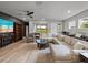 Bright living room featuring a large sectional sofa, built-in bookshelves, and a view of the backyard at 8119 Trimbelle Ter, Parrish, FL 34219