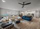 Spacious living room featuring a sectional sofa, ceiling fan, and view into the kitchen with island seating at 8119 Trimbelle Ter, Parrish, FL 34219