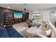 Bright living room featuring a large sectional sofa, built-in bookshelves, and a modern ceiling fan at 8119 Trimbelle Ter, Parrish, FL 34219