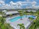 Aerial view of the community pool with palm trees, lounge chairs, and a covered seating area at 8119 Trimbelle Ter, Parrish, FL 34219