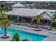 Community pool has a covered seating area, lounge chairs, and palm trees at 8119 Trimbelle Ter, Parrish, FL 34219