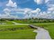 Manicured walking path overlooking community pond surrounded by lush green space at 8119 Trimbelle Ter, Parrish, FL 34219