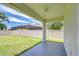 A covered patio overlooks the expansive backyard with lush green grass and a white fence at 828 Terra Vista St, Brandon, FL 33511