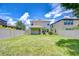 Large grassy backyard featuring a covered patio, privacy fence, and a glimpse of neighboring homes at 828 Terra Vista St, Brandon, FL 33511