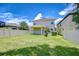 A covered patio overlooks the expansive backyard with lush green grass and a white fence at 828 Terra Vista St, Brandon, FL 33511