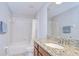 Well-lit bathroom with granite vanity, shower and tub with a shower curtain at 828 Terra Vista St, Brandon, FL 33511