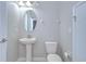 Powder room featuring a pedestal sink, toilet, oval mirror, and a door at 828 Terra Vista St, Brandon, FL 33511