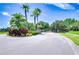 Community entrance featuring brick accents, lush landscaping, and vibrant palm trees under a bright sky at 828 Terra Vista St, Brandon, FL 33511