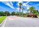 Community entrance featuring brick accents, lush landscaping, and vibrant palm trees under a bright sky at 828 Terra Vista St, Brandon, FL 33511