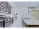 Lovely kitchen featuring a granite-topped island, stainless steel appliances, and easy access to the stairs at 828 Terra Vista St, Brandon, FL 33511