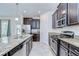 Well-equipped kitchen featuring granite countertops, stainless steel appliances, and stylish dark wood cabinets at 828 Terra Vista St, Brandon, FL 33511
