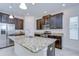 Stylish kitchen boasts granite countertops, dark wood cabinets, stainless steel appliances and a functional kitchen island at 828 Terra Vista St, Brandon, FL 33511
