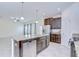 Open-concept kitchen with a granite island, dark cabinets, stainless appliances, and easy access to the living room at 828 Terra Vista St, Brandon, FL 33511