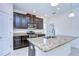 Modern kitchen features dark cabinets, granite countertops, and a large island with a sink at 828 Terra Vista St, Brandon, FL 33511