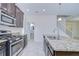 Lovely kitchen featuring a granite-topped island, stainless steel appliances, and easy access to the stairs at 828 Terra Vista St, Brandon, FL 33511