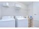 Functional laundry room with modern washer, dryer, wire shelving, and storage at 828 Terra Vista St, Brandon, FL 33511