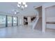 Open-concept living room featuring tile floors, staircase and modern kitchen with stainless steel appliances at 828 Terra Vista St, Brandon, FL 33511
