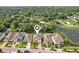 Aerial view of home in established neighborhood with mature landscaping and pond in the back at 8305 Praise Dr, Tampa, FL 33625